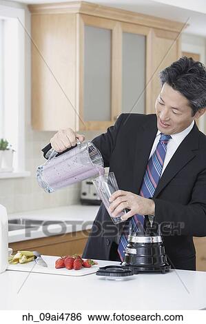 Asian businessman making fruit smoothie View Large Photo Image Stock Photograph - Asian businessman making fruit smoothie. Fotosearch