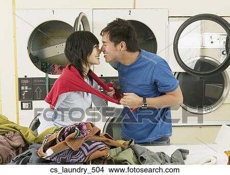 Picture - Asian couple hugging in Laundromat. Fotosearch