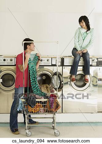 Picture - Asian couple in laundromat. Fotosearch
