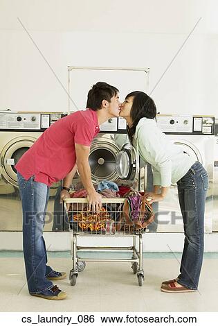 Stock Photograph - Asian couple kissing in laundromat. Fotosearch