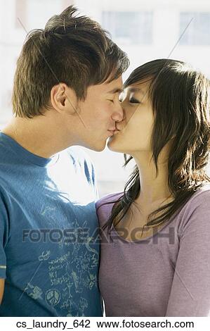 Stock Image - Asian couple kissing. Fotosearch