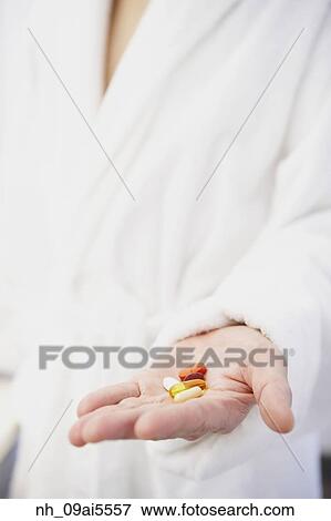 Asian man holding pills in hand View Large Photo Image Stock Photo - Asian man holding pills in hand. Fotosearch