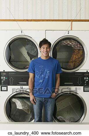 Stock Image - Asian man in Laundromat. Fotosearch