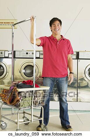 Stock Photo - Asian man in laundromat. Fotosearch