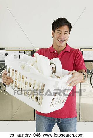 Stock Photograph - Asian man in laundromat. Fotosearch
