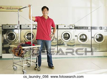 Stock Photograph - Asian man in laundromat. Fotosearch