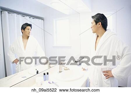 Asian man looking in bathroom mirror View Large Photo Image Stock Image - Asian man looking in bathroom mirror. Fotosearch