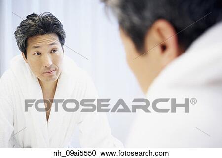 Asian man looking in bathroom mirror View Large Photo Image Stock Image - Asian man looking in bathroom mirror. Fotosearch