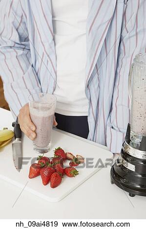 Asian man making fruit smoothie View Large Photo Image Stock Photo - Asian man making fruit smoothie. Fotosearch