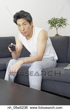 Asian man pointing remote control View Large Photo Image Stock Photograph - Asian man pointing remote control. Fotosearch