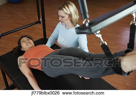 Asian woman exercising with personal trainer View Large Photo Image Stock Photograph - Asian woman exercising with personal trainer. Fotosearch