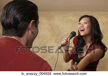 Stock Photography - Asian woman singing with microphone. Fotosearch