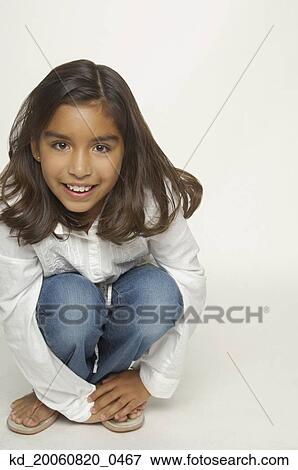 Close up of Hispanic girl crouching View Large Photo Image Stock Photo - Close up of Hispanic girl crouching. Fotosearch