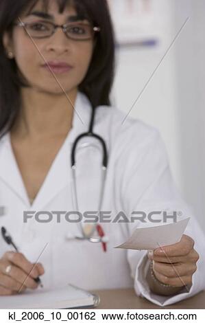 Stock Image - Female doctor handing over prescription. Fotosearch