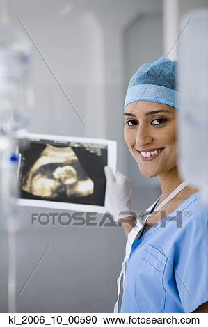 Female doctor holding sonogram View Large Photo Image Stock Image - Female doctor holding sonogram. Fotosearch
