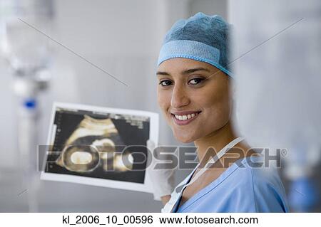 Stock Photograph - Female doctor holding sonogram. Fotosearch