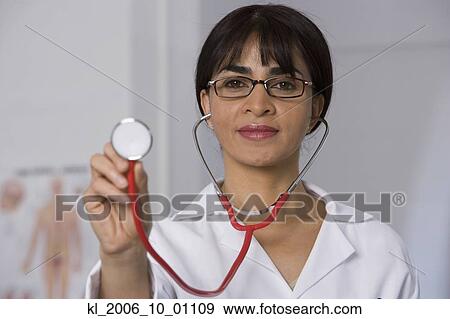 Female doctor holding up stethoscope View Large Photo Image Stock Photo - Female doctor holding up stethoscope. Fotosearch