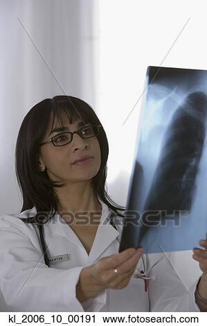 Stock Image - Female doctor looking at x-ray. Fotosearch