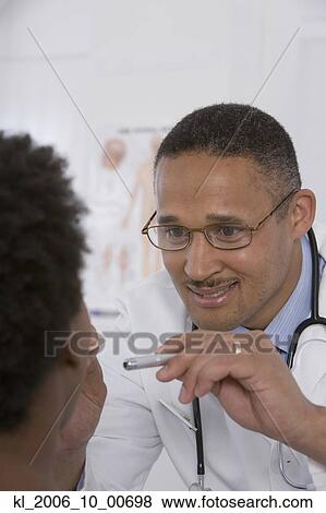 Stock Photo - Female doctor putting on surgical gloves. Fotosearch