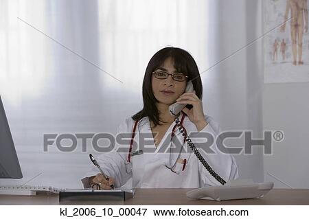 Stock Photo - Female doctor talking on telephone. Fotosearch