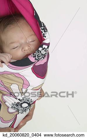 Picture - Hispanic baby sleeping in wrap. Fotosearch