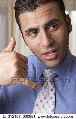 Hispanic businessman mimicking telephone with hand View Large Photo Image Stock Image - Hispanic businessman mimicking telephone with hand. Fotosearch