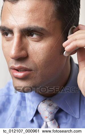 Hispanic businessman wearing hands free device View Large Photo Image Stock Image - Hispanic businessman wearing hands free device. Fotosearch