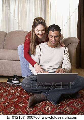 Hispanic couple looking at laptop View Large Photo Image Stock Image - Hispanic couple looking at laptop. Fotosearch