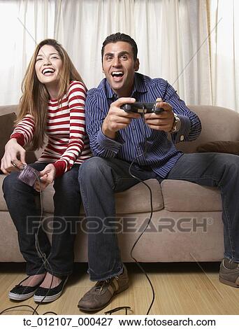 Stock Photo - Hispanic couple playing video game. Fotosearch