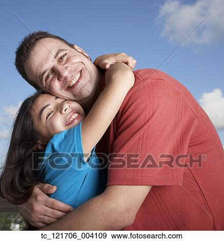 Stock Photo - Hispanic father and daughter hugging. Fotosearch