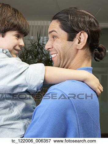 Hispanic father and son smiling at each other View Large Photo Image Stock Photo - Hispanic father and son smiling at each other. Fotosearch
