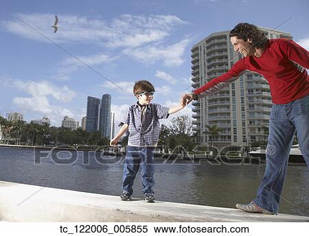 Stock Photography - Hispanic father holding son’s hand. Fotosearch
