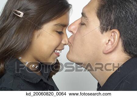 Picture - Hispanic father kissing daughter’s nose. Fotosearch