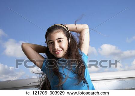 Hispanic girl listening to headphones View Large Photo Image Stock Photo - Hispanic girl listening to headphones. Fotosearch