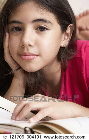 Stock Image - Hispanic girl resting face in hand. Fotosearch