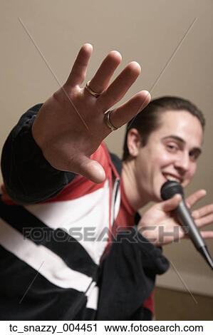 Stock Image - Hispanic man singing with microphone. Fotosearch