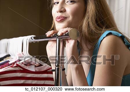 Hispanic woman leaning on rack of clothing View Large Photo Image Stock Image - Hispanic woman leaning on rack of clothing. Fotosearch