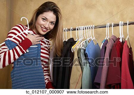 Hispanic woman looking at clothing on rack View Large Photo Image Stock Photo - Hispanic woman looking at clothing on rack. Fotosearch
