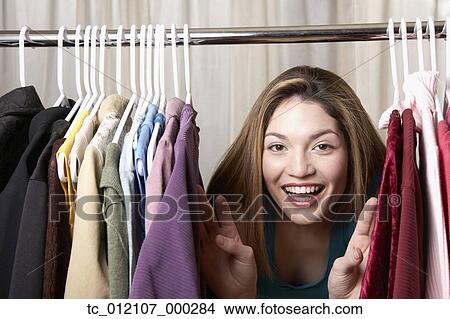 Hispanic woman looking through rack of clothing View Large Photo Image Picture - Hispanic woman looking through rack of clothing. Fotosearch