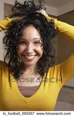 Stock Photo - Hispanic woman playing with hair. Fotosearch