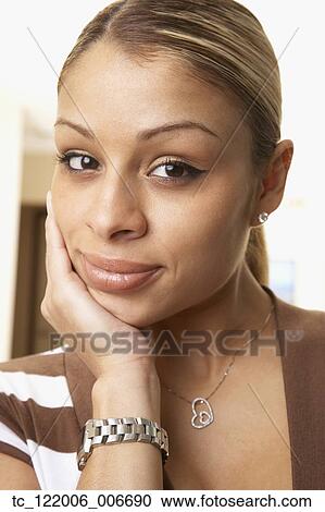 Hispanic woman resting chin in hand View Large Photo Image Stock Image - Hispanic woman resting chin in hand. Fotosearch