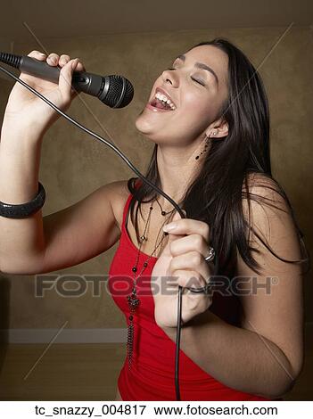 Stock Photo - Hispanic woman singing with microphone. Fotosearch