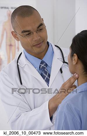 Stock Image - Male doctor examining patient. Fotosearch