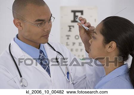 Stock Image - Male doctor examining patient. Fotosearch