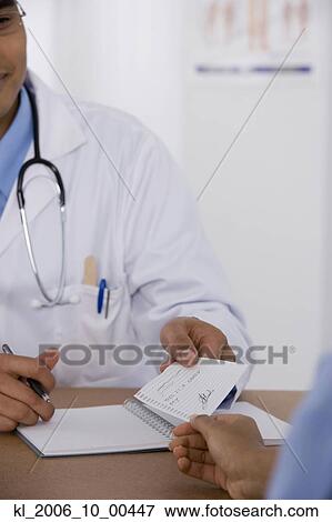 Male doctor handing prescription to patient View Large Photo Image Stock Photo - Male doctor handing prescription to patient. Fotosearch
