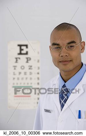 Stock Photograph - Male doctor in front of eye chart. Fotosearch