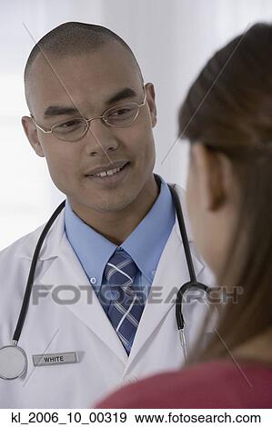 Male doctor talking to patient View Large Photo Image Stock Photo - Male doctor talking to patient. Fotosearch