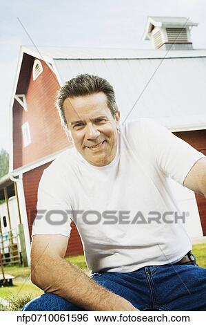 Man sitting in front of barn View Large Photo Image Stock Photograph - Man sitting in front of barn. Fotosearch