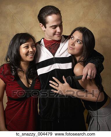 Man with microphone hugging two women View Large Photo Image Stock Photo - Man with microphone hugging two women. Fotosearch