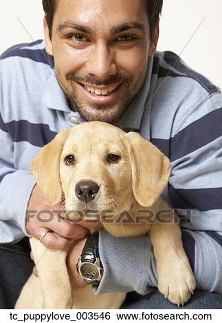 Mixed Race man holding puppy dog View Large Photo Image Stock Photograph - Mixed Race man holding puppy dog. Fotosearch